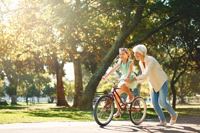 grandmother teaching granddaughter how to ride a bike