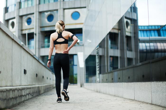 woman holding her back after jogging