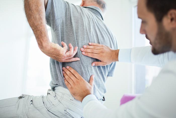 doctor examining patient's middle back