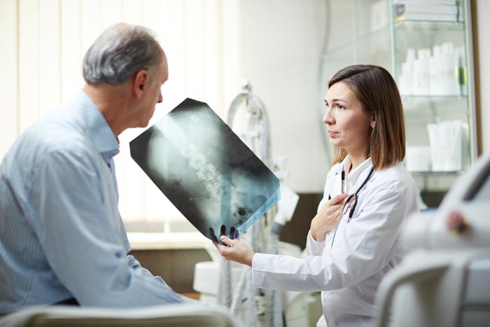doctor showing patient an x-ray of the spine