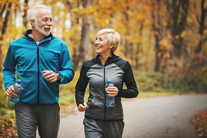 middle aged couple jogging in park