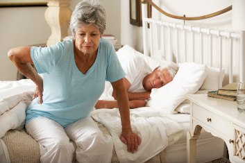 woman holding back after bad nights sleep