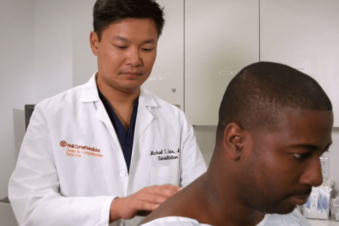 Dr. assessing patient's spine